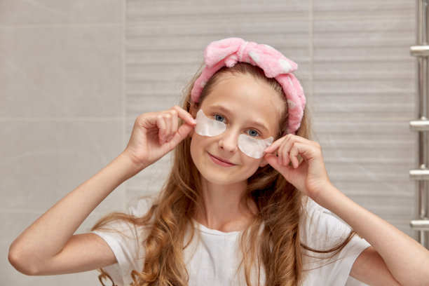 眼睛戴着眼罩，头上缠着绷带的女孩看着镜头。图片下载