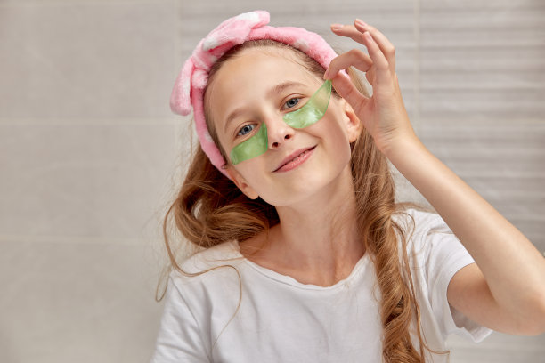 金发女孩喜欢用凝胶眼罩，微笑着看着镜头。图片下载