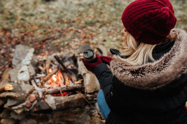 年轻女性坐在篝火旁图片下载