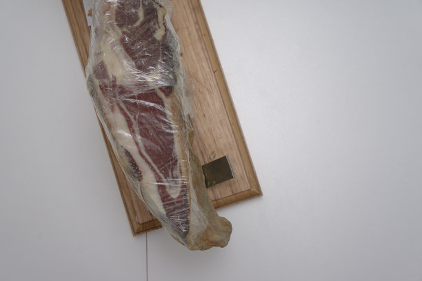 白色桌子上放着西班牙火腿和塑料保护膜图片下载