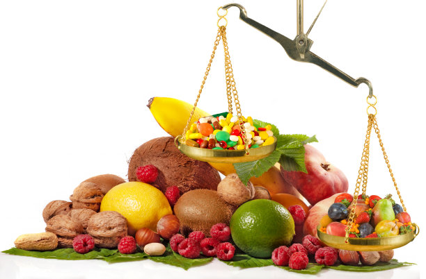 在一堆水果的背景下，在秤上的药丸和水果图片下载