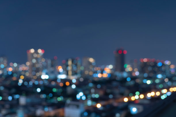 虚景抽象背景的摩天大楼在曼谷市，泰国与灯光，模糊的照片在晚上的时间。城市景观。图片下载