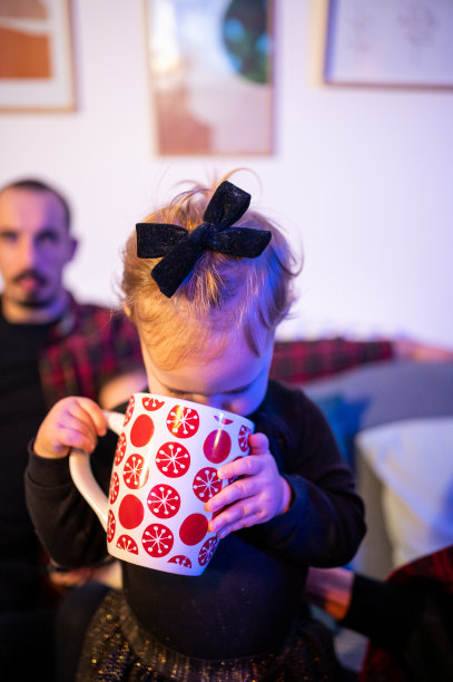 可爱的非洲小女孩与一杯热可可靠近圣诞树库存照片图片下载