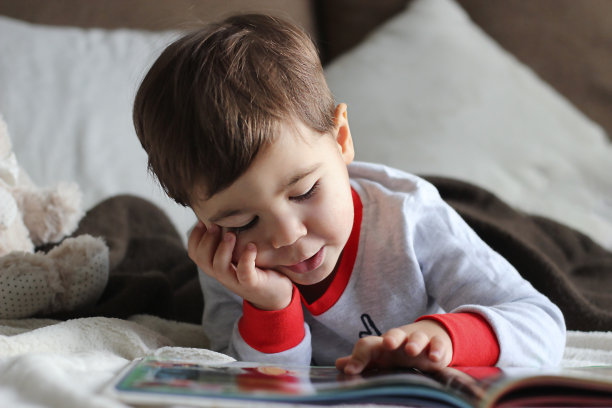 一个躺着看书的小男孩的肖像图片下载