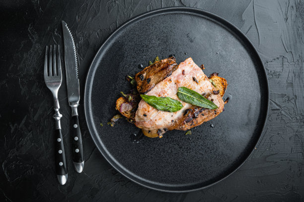 肝、培根和洋葱放在烤好的面包上，放在黑面盘子上，俯视图图片下载