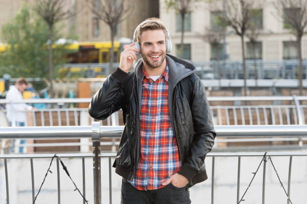 自我提高。帅哥喜欢音乐都市背景。远程教育。远程学习。现代教育。播客的青年。在线教育课程。听音乐。学生使用耳机学习图片下载