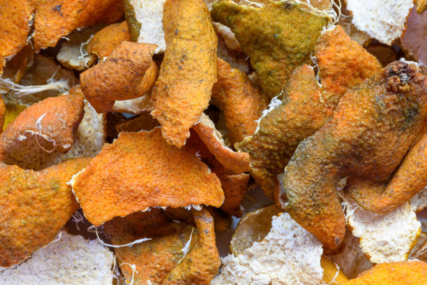 图片自制的蜜饯橘子皮在阳光下干燥的过程，在白色的表面。图片下载