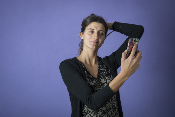 年轻女子在用手机自拍图片下载