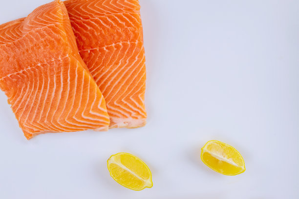 两块生鲑鱼片配柠檬，白色背景图片下载