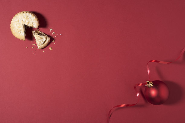 圣诞食品百果馅饼和圣诞装饰在一个红色的背景与拷贝空间在中间-库存照片图片下载