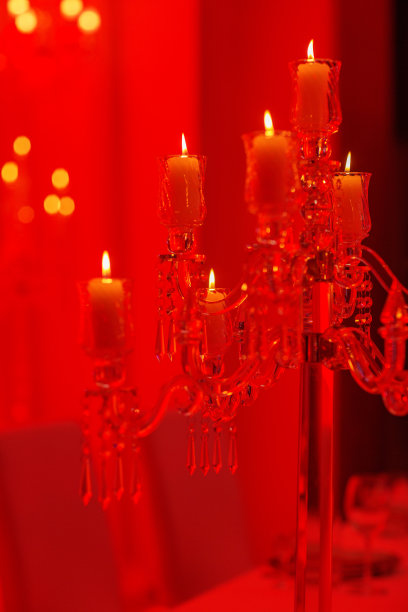 喜庆的婚宴桌上有燃烧的蜡烛和红色的水晶。水晶烛台作为婚礼的中心装饰品。图片下载