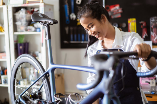 自行车修理技师女自行车被修理齿轮自行车店。图片下载