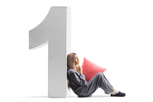 穿着睡衣坐在地板上靠在一号上沉思的女人图片下载