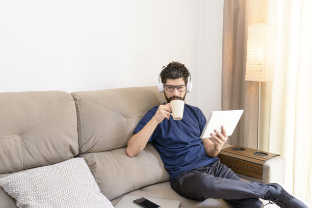 拉丁人喝茶和通过数字设备阅读图片下载