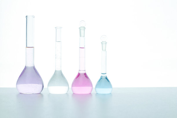 透明烧瓶上用彩色试剂在白色背景上分离。排成一排的有选择性的重点。医疗、科学、保健理念。图片下载