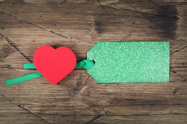 红心与空白纸标签在木制背景。情人节或母亲节的概念。标签上的文本空间。图片下载