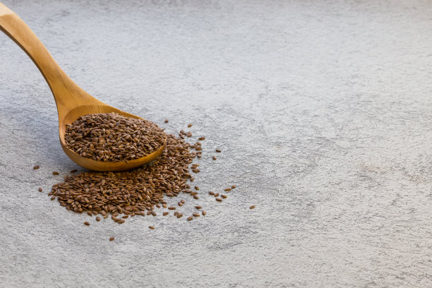 灰色混凝土背景下，木勺里放着亚麻籽，是omega-3、维生素B和C、碘、磷、钾、镁、镍的天然来源，是一种可以降低胆固醇的饮食产品图片下载