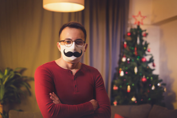 一个白人男子的肖像与白色医疗面罩和眼镜。图片下载