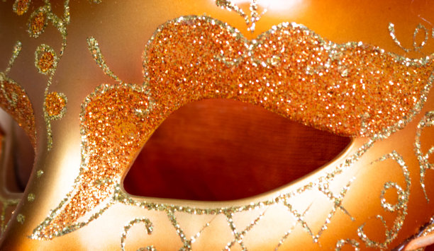 细部的威尼斯狂欢节女性橙色面具配以金色闪亮的装饰图片下载