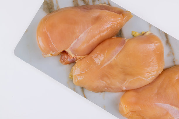 在白色背景上分离的生鸡胸。图片下载