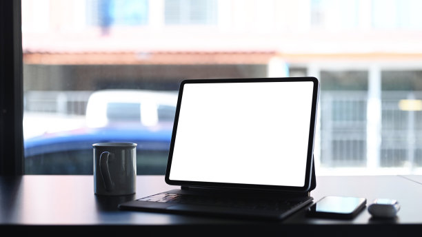 在空白的木桌上模拟平板电脑、空白屏幕、咖啡杯和智能手机。空白屏幕用于图形显示蒙太奇。图片下载