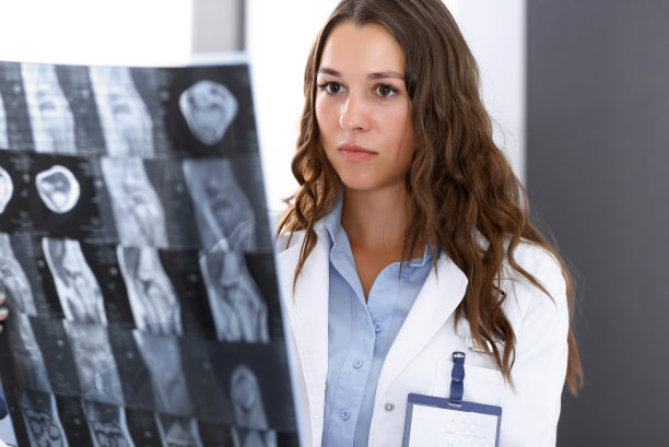 一位女医生站在医院窗户附近检查x光照片。在工作中的外科医生或整形外科医生医疗保健理念图片下载