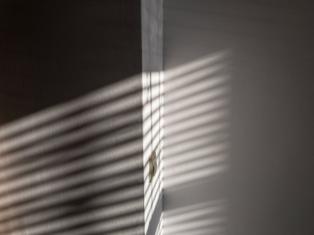 影子楼。抽象的光线，黑色的阴影从窗户覆盖在白色纹理的墙壁上。阳光建筑背景。叠加效果的照片和设计。图片下载