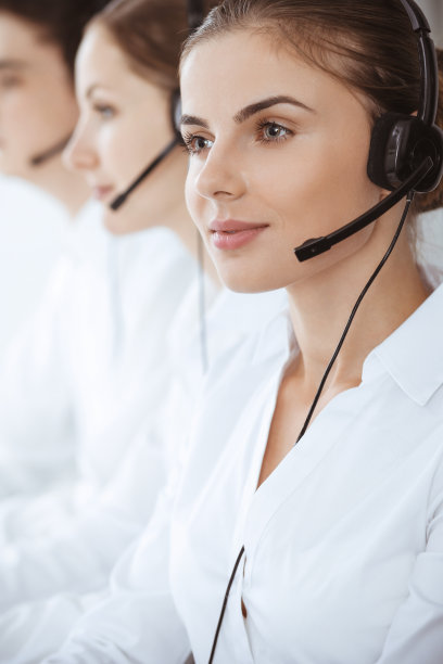 呼叫中心。漂亮的年轻女子使用耳机和电脑帮助客户。经营理念图片下载