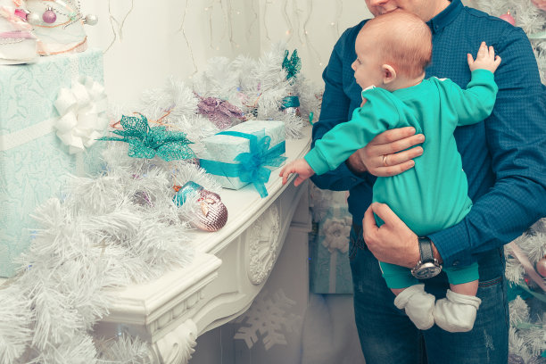 圣诞快乐。父亲给婴儿看圣诞礼物图片下载