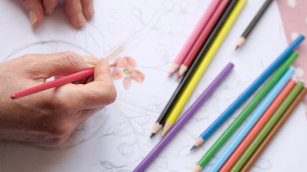 女人的手在画一朵花。图片下载