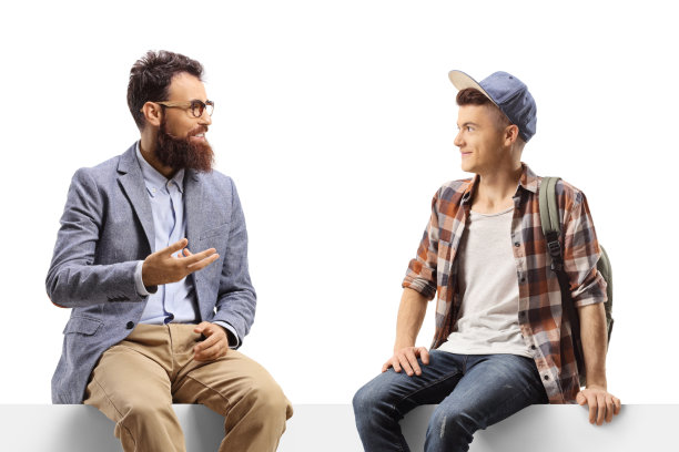 父亲和十几岁的儿子坐在讨论会上图片下载