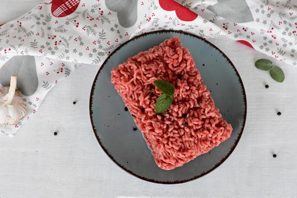 肉末，新鲜生牛肉，黑胡椒，薄荷，罗勒和大蒜装盘，白色木质背景图片下载