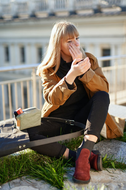 金发女女孩穿着橙色外套在户外化妆图片下载