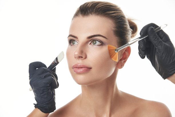 美丽的白人妇女的肖像望着别处和手在黑色的手套拿着刷子在洗脸图片下载