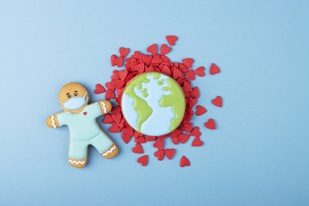 姜饼医生戴着医用面具，地球上的红心在蓝色的背景下图片下载