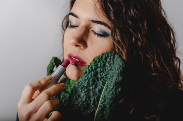 口红和绿叶的女人肖像。素材图片