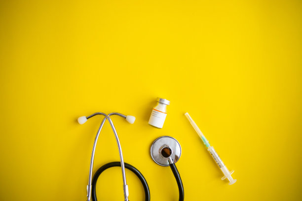 黄色背景的Covid-19冠状病毒疫苗瓶子- Covid-19疫苗治疗。新型冠状病毒疫苗瓶、注射器注射工具图片下载