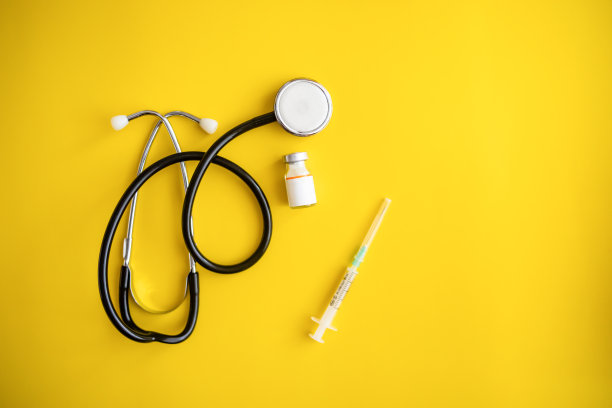 黄色背景的Covid-19冠状病毒疫苗瓶子- Covid-19疫苗治疗。新型冠状病毒疫苗瓶、注射器注射工具图片下载