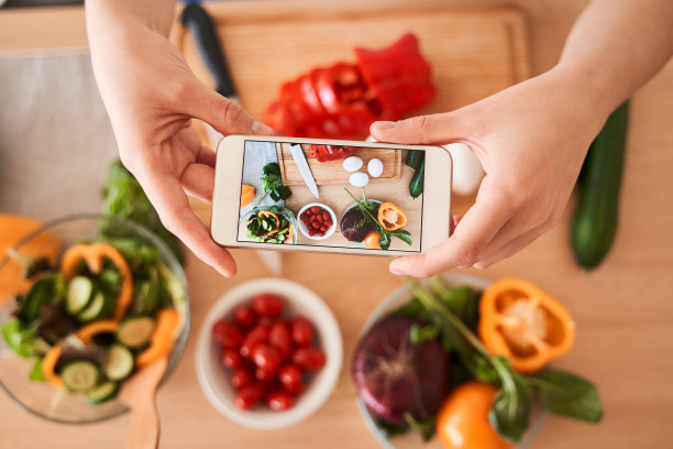 一个女人正在用智能手机拍照图片下载