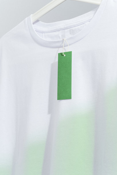 白色t恤上印有空白的绿色价格标签，挂在白色衣架上图片下载