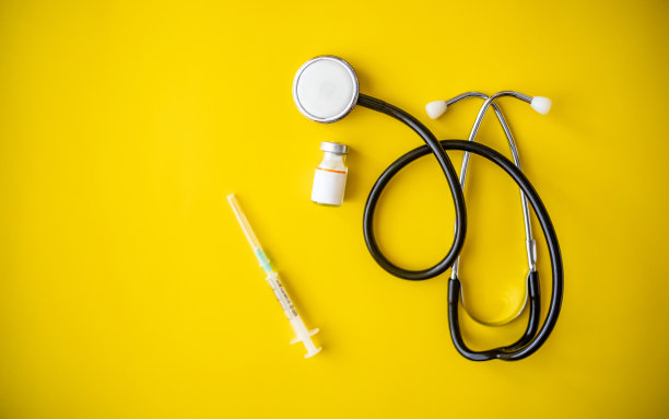 黄色背景的Covid-19冠状病毒疫苗瓶子- Covid-19疫苗治疗。新型冠状病毒疫苗瓶、注射器注射工具图片下载