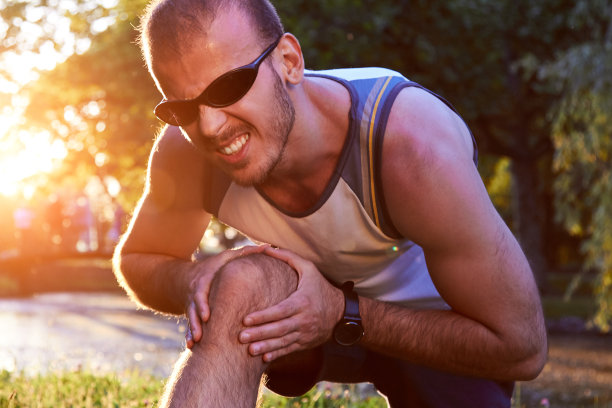 运动慢跑时在公园跑步受伤，小伙子膝盖有疼痛问题。图片下载