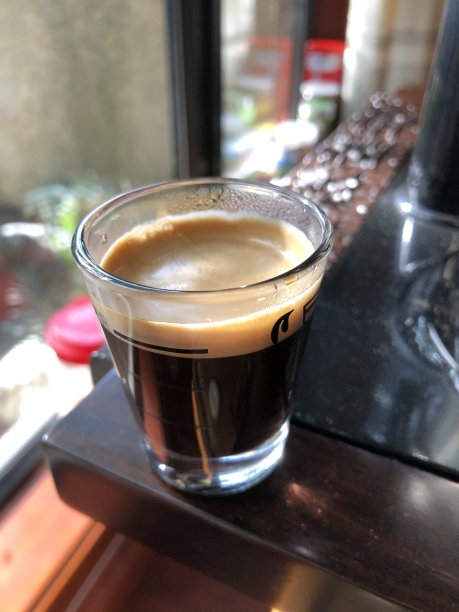 在桌子角落的玻璃杯里的浓缩咖啡的观点图片下载