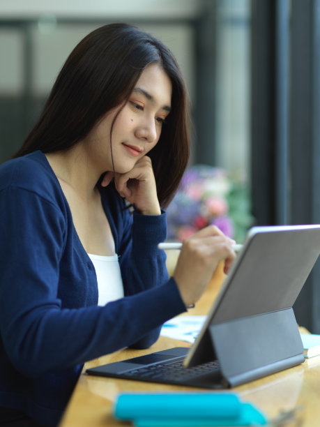 女大学生在咖啡馆用平板电脑做作业图片下载