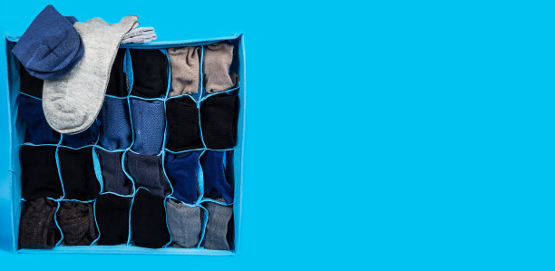 男多色袜子堆放在包装上的蓝色背景。礼物。图片下载