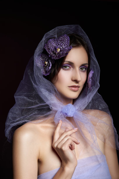 美丽的黑发女人与自然的化妆摆姿势在黑暗的背景。光滑细腻的面部肌肤图片下载