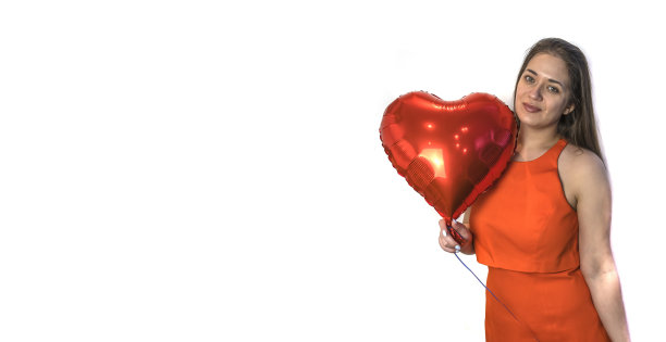 情人节快乐!一个拿着心形气球的年轻女子。副本的空间。图片下载