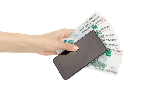 手拿俄罗斯卢布和手机，孤立在白茫茫之中图片下载
