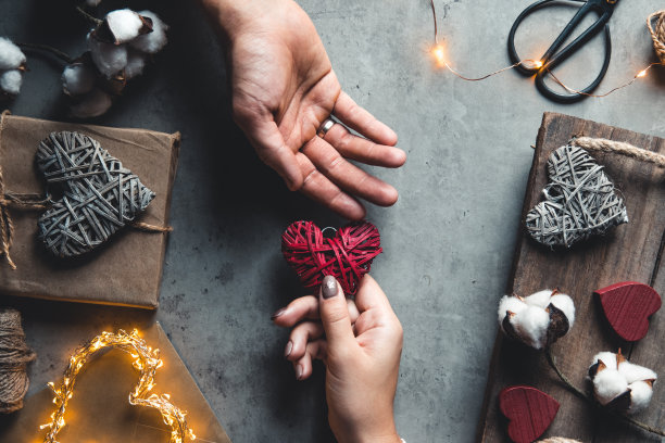 男人的手牵着女人的手。心在手中。浪漫,礼物。情人节图片下载