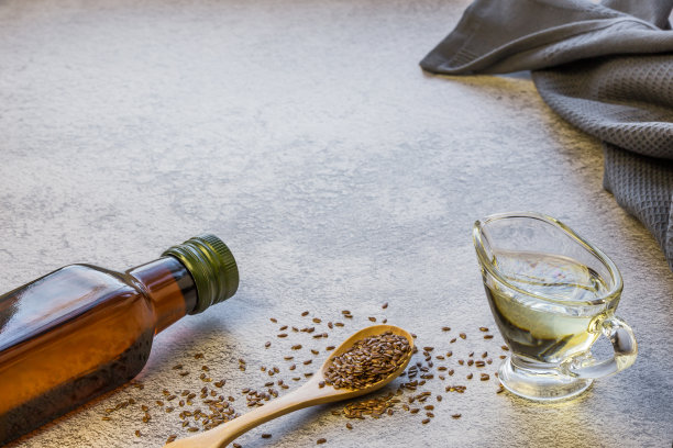 玻璃瓶里的亚麻籽油，木勺里的亚麻籽，富含欧米伽-3的蔬菜，可以降低胆固醇，用作饮食沙拉酱，美容，草药图片下载